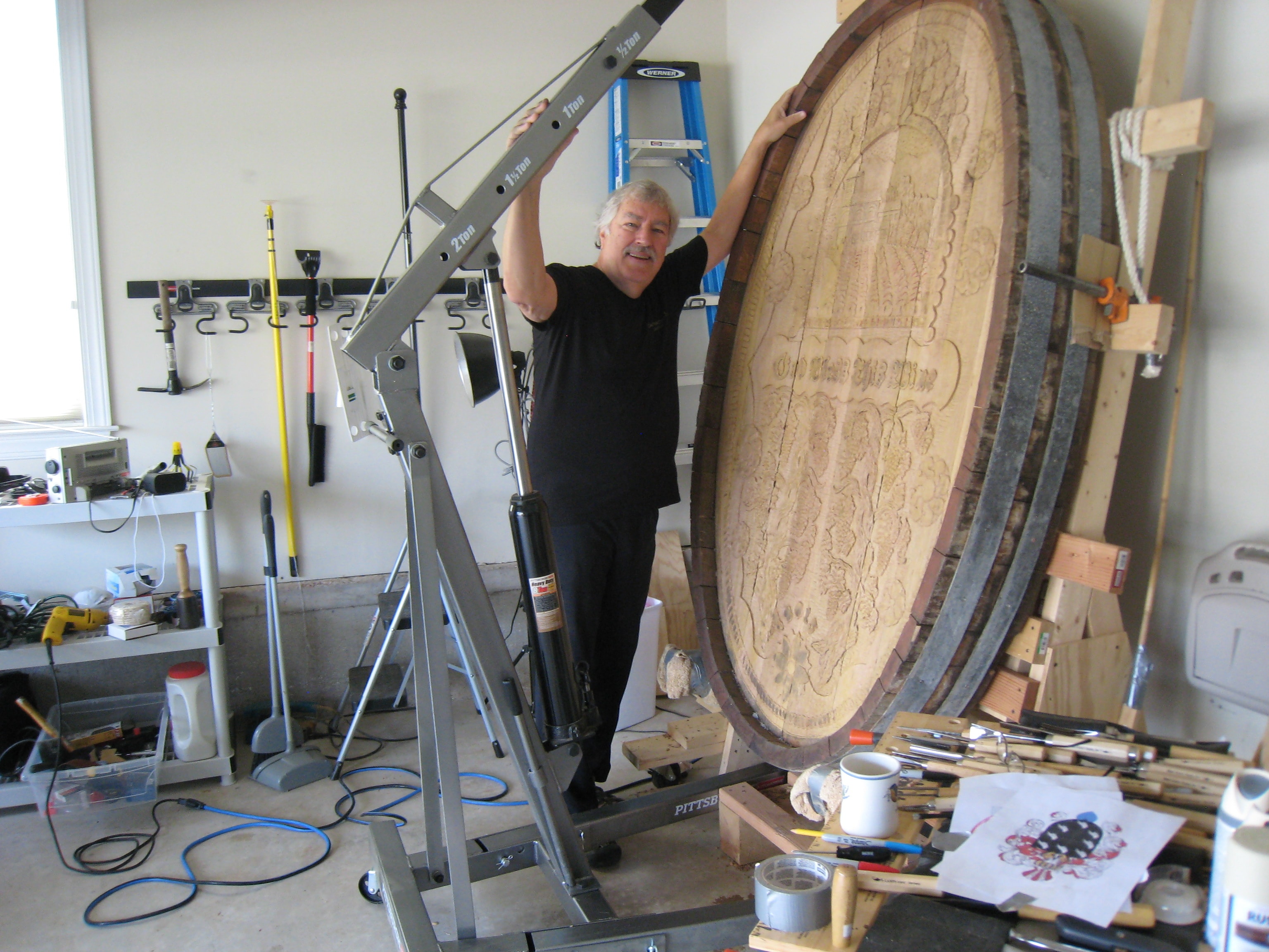 The artist steadying the large cask end with a 2-ton garage crane in the workshop